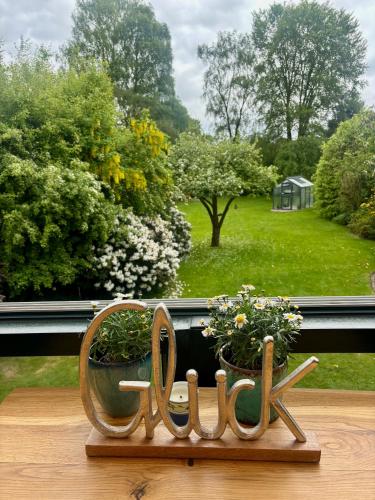 a wooden sign sitting on a window sill with flowers at Villa Topas in Wilhelmshaven