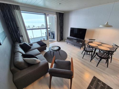 a living room with a couch and a table at Timantti Apartments by Hiekka Booking in Kalajoki