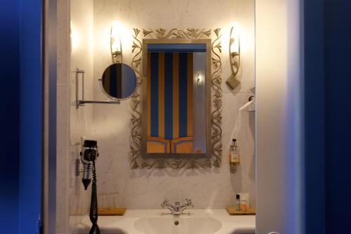 a bathroom with a sink and a mirror on the wall at Logis Hôtel Beauséjour Colmar in Colmar