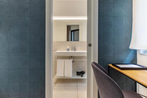 a bathroom with a sink and a desk with chairs at Taormina Town - Guesthouse Sicily in Taormina