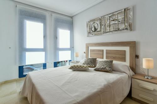 a bedroom with a large bed with a clock on the wall at Gala Centro Modern I in Torrevieja