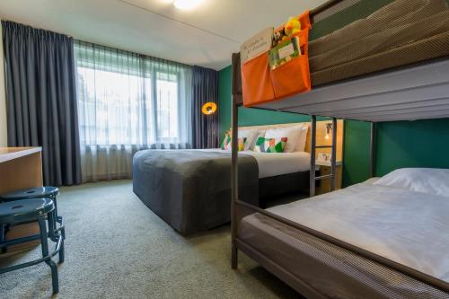 a hotel room with two bunk beds and a window at Landgoed Mennorode in Elspeet