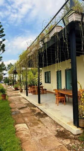 a patio of a house with a wooden table at Sa Đéc Glamping in Ấp Ðông Qứi