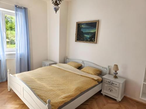 a white bedroom with a bed and a picture on the wall at White Haven Private Sauna & Pool in Chřibská