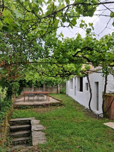 a picnic table in a yard next to a building at Quinta Farm Stay - Silence and Nature Retreat in Lousã