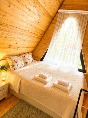 a bed in a wooden room with a window at Achkhoti Paradise in Kazbegi
