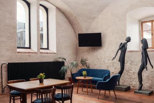 a room with a table and chairs and two statues at Zámecký Hotel Litomyšl in Litomyšl