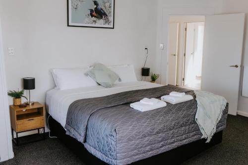 a bedroom with a bed with two towels on it at Marsden Manor - Spacious house with large pool in Greymouth