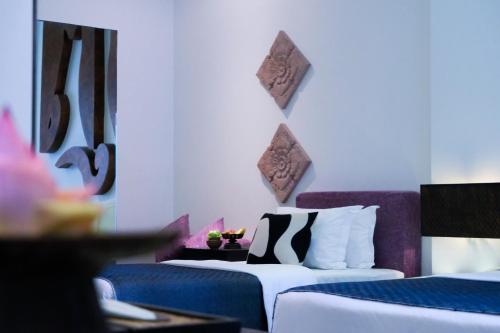 a hotel room with two beds and a couch at Golden Temple Villa in Siem Reap
