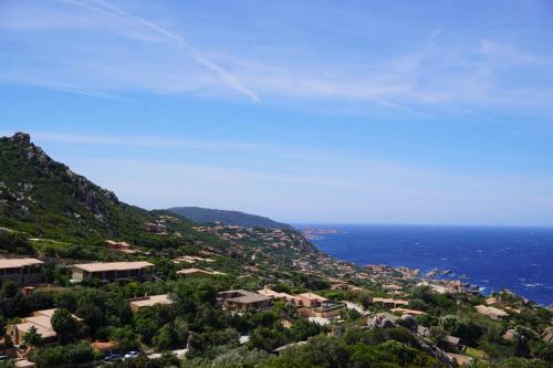 a view of a town on a hill next to the ocean at Roccette OndaTURCHESE, Vista Mare e Jacuzzi Privata in Costa Paradiso