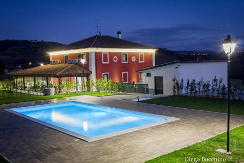 a large swimming pool in front of a house at Agriturismo Villa Luisa in Apice