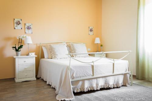 a bedroom with a white bed and a white nightstand at Agriturismo Villa Luisa in Apice