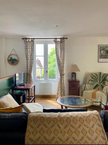 a living room with a couch and a glass table at Joli Canard in Badefols-dʼAns