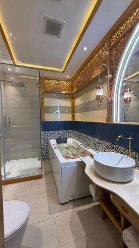 a bathroom with a tub and a shower and a sink at Suroor Houseboat in Srinagar