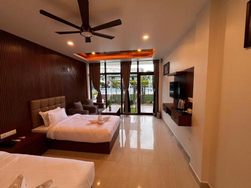 a hotel room with two beds and a ceiling fan at Emmonlang Resort and Restaurant in Dingpasoh