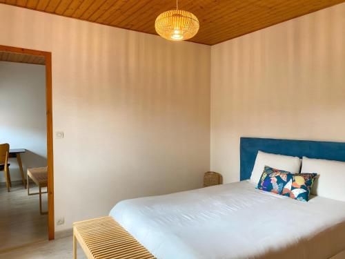 a bedroom with a bed with a blue headboard at Le Logis de la Forge-10min puydufou in Mortagne-sur-Sèvre