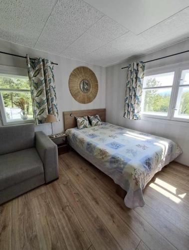a bedroom with a bed and a couch and windows at Górska Otulina in Wilkowisko