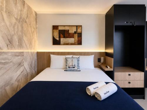 a bedroom with a bed with two towels on it at Emunah Flat Luxo Cabedelo • Piscina no Rooftop in Cabedelo