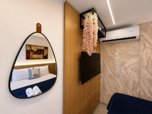 a bedroom with a mirror and a bed and a shower at Emunah Flat Luxo Cabedelo • Piscina no Rooftop in Cabedelo