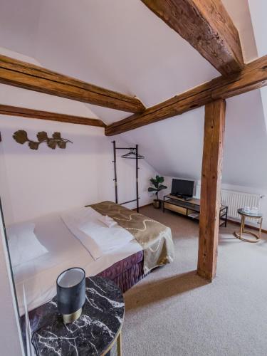 a bedroom with a large bed and a table at Hotel Rytířsko in Jamné