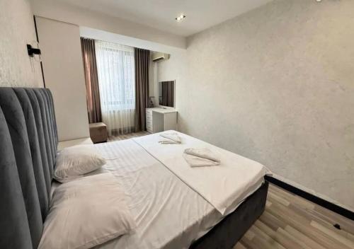 a bedroom with a bed with white sheets at Republic Square Modern Flat in Yerevan