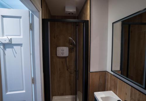 a bathroom with a shower and a sink and a mirror at Hidden Gem Townhouse - Cahersiveen in Cahersiveen