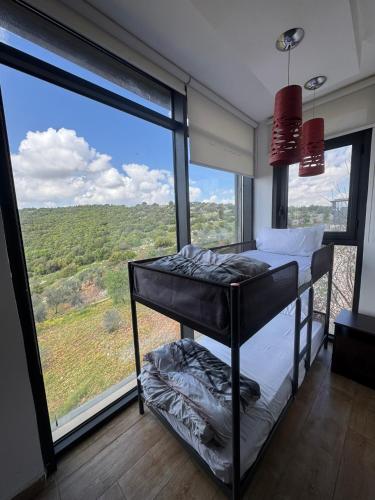 a bedroom with a bunk bed in front of a large window at Shams Farm in Ajloun