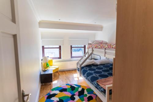 a small bedroom with a bunk bed and a rug at Hidden Gem Townhouse - Cahersiveen in Cahersiveen