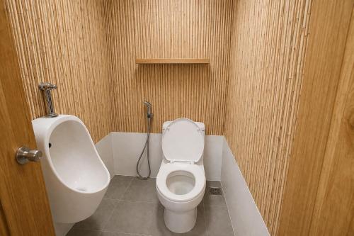 a bathroom with a white toilet and a urinal at Taj Resort and Spa in Boracay