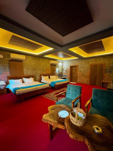 a room with two beds and a table and chairs at Olive in Tāla