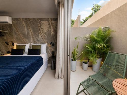 a bedroom with a bed and a chair on a balcony at Setai Yatch Garden-Deluxe Praia-Piscina no rooftop in João Pessoa