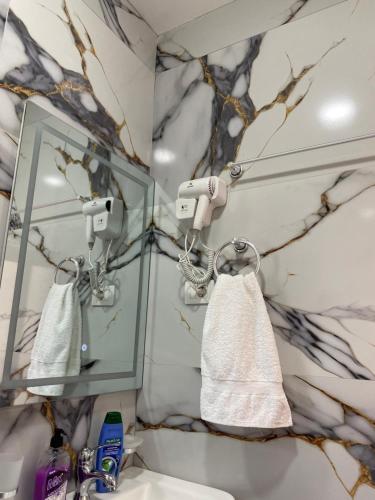 a bathroom with a mirror and a white towel at Guesthouse SELI in Berat