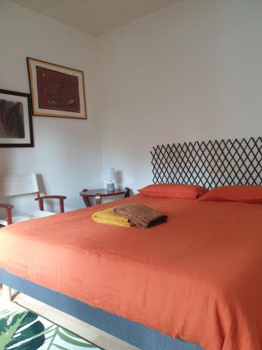 a bedroom with a bed with an orange bedspread at La Flibuste in Andernos-les-Bains