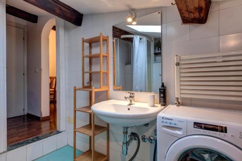 a bathroom with a sink and a washing machine at Taddeo Apartement by Mamo Florence in Florence