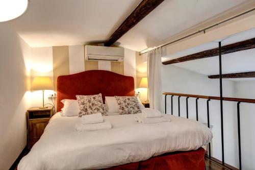 a bedroom with a large bed with white sheets and pillows at Taddeo Apartement by Mamo Florence in Florence