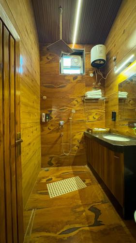 a wooden bathroom with a shower and a sink at Olive in Tāla