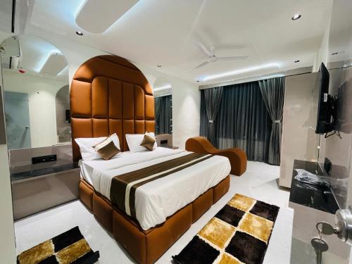a bedroom with a large bed and a bathroom at Hotel Pacific Regency in Ahmedabad