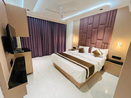 a bedroom with a large bed with a large headboard at Hotel Pacific Regency in Ahmedabad