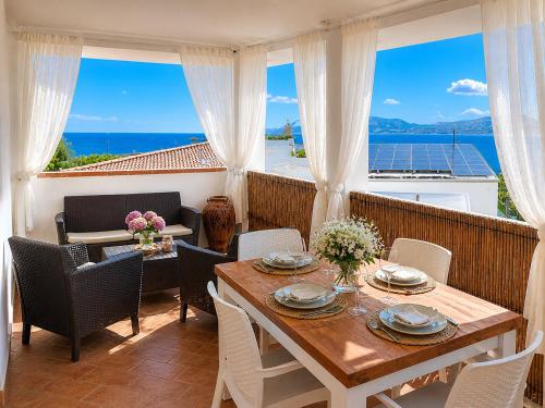 a dining room with a table and chairs and the ocean at La Conia Sea View Retreat in Cannigione