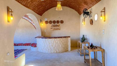 a room with a bed and two tables in it at Agmair Amellal in Siwa