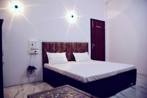a bedroom with a bed with two lights above it at Hotel Bhatner Inn in Hanumāngarh