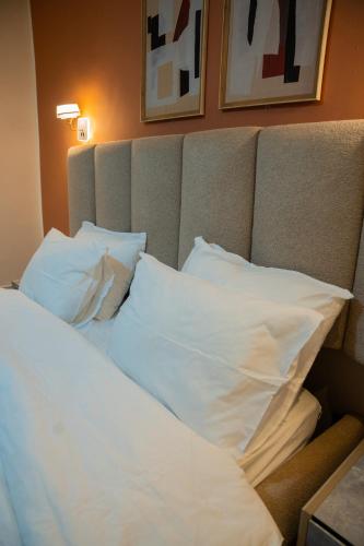 a bed with white pillows in a hotel room at Appartements Quartier Kabulameshi - Lubumbashi in Lubumbashi