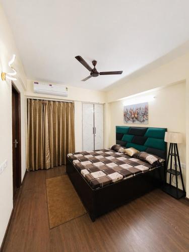 a bedroom with a large bed and a ceiling fan at AM Living in Ghaziabad