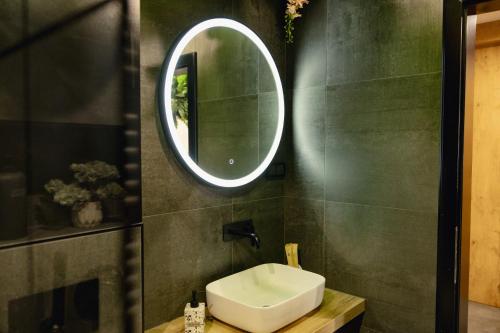 a bathroom with a sink and a mirror on the wall at Navigator Apartment in Bijeljina