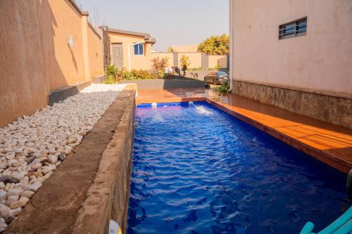 a swimming pool with blue water in a backyard at Appartements Quartier Kabulameshi - Lubumbashi in Lubumbashi