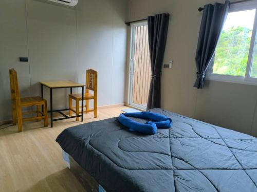 a bedroom with a bed with a blue pillow on it at Chill House Khaokho in Khao Kho