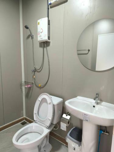 a bathroom with a toilet and a sink and a mirror at Chill House Khaokho in Khao Kho