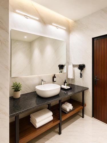 a bathroom with a sink and a large mirror at Tiraya Luxury Riverside Hotel & Café in Gushaini
