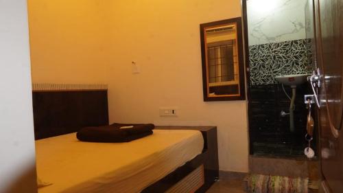 a small bedroom with a bed and a mirror at Hotel vasaavi Rameswaram in Rāmeswaram