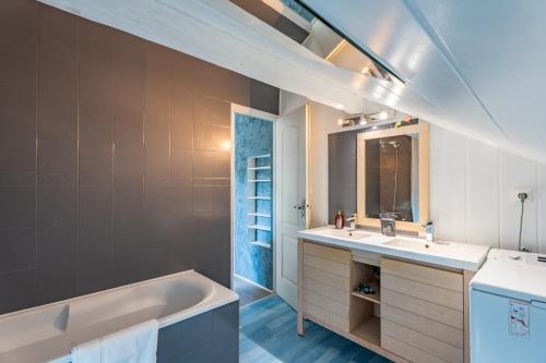 a bathroom with a tub and a sink at Waterfront in Lugrin